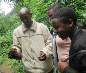 Denis shows his students seeds germinating from elephant dung at the Bwindi Impenetrable National Park.